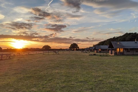 A beautiful sunset casts warm light over the Hideaway glamping site on the North Norfolk Coast