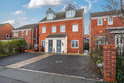 Front view of the home showing a wide driveway area for parking.