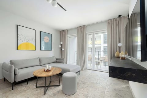Bright living area with a cozy sofa, modern coffee table, and balcony access.