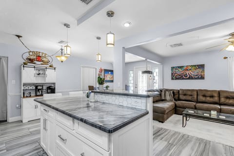 Open floor plan with kitchen island, living and dining room, and coffee bar