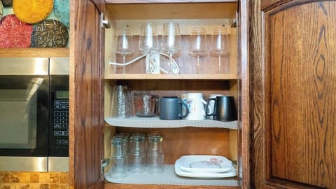 This kitchen cabinet is stocked with essentials including wine glasses, coffee mugs, drinking glasses, and plates. Whether you’re enjoying your morning coffee or hosting with a glass of wine, everything you need is neatly organized and ready to use.