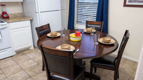 Cozy Wood Dining Nook
Round wood table seats four comfortably with leather chairs and sunny yellow fruit centerpiece. Adjacent to kitchen and window views; perfect for casual breakfasts or intimate family meals in your beach condo.
