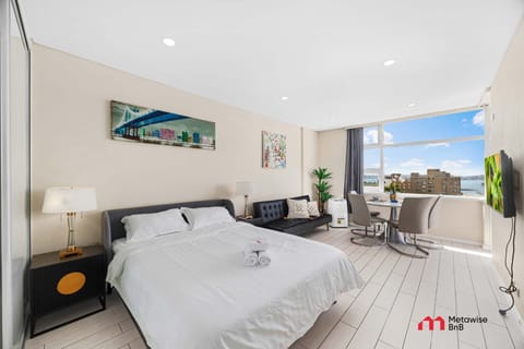 Bedroom featuring a queen-size bed, bedside tables, and harbour views.