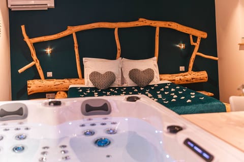 Jacuzzi et lit romantique en arrière-plan
