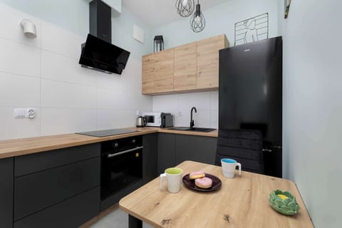 Stylish contemporary kitchen with wooden countertop and black cabinets.