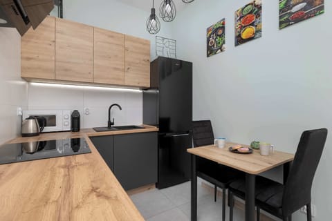 Open-plan kitchenette with dining table and modern appliances.