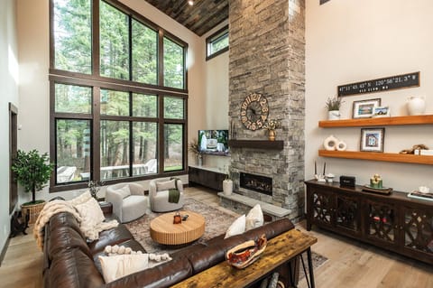 A soaring great room where towering windows bring the forest indoors.