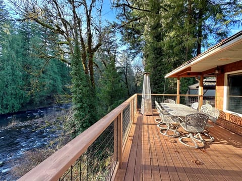 Bring everyone together to soak up the river, sun and surrounding trees on 3 large decks overlooking the Salmon River from the main house. This deck is just off the Great Room and has plenty of room to eat outside. There's also a covered grilling station. 