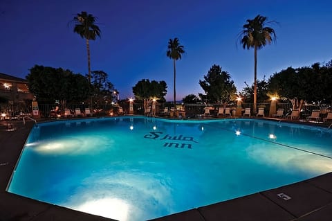 Dive into a glowing pool oasis under the stars.