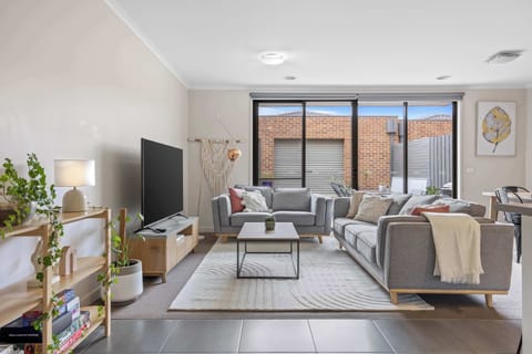 Open plan living room with flat screen TV and ample seating.