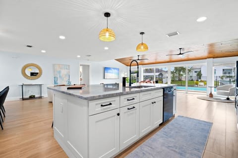 Open-concept kitchen and living space with pool views and seamless indoor–outdoor flow.