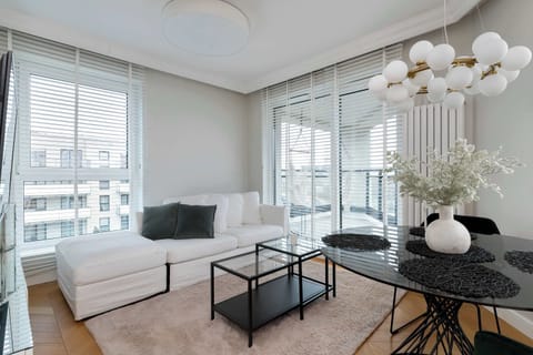 Bright living room with comfortable sofa, large windows, elegant furniture, and soft neutral tones creating a calm atmosphere.