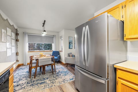 Kitchen and dining area view, showing the stainless steel refrigerator and dining table.