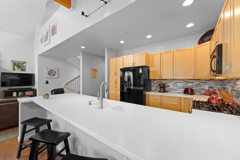 Full kitchen with breakfast bar seating four.