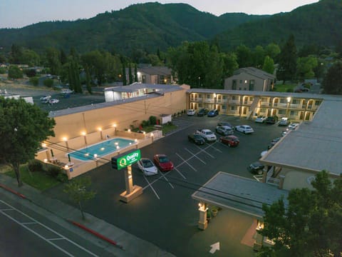 Evening view of Quality Inn with pool and parking area