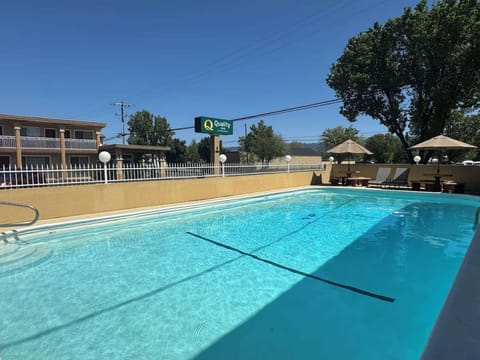 Clean swimming pool with signboard and loungers