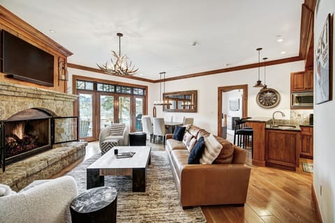 The inviting layout harmonizes rich wood finishes with luxurious furnishings, ensuring guests feel right at home amidst the breathtaking snow-capped peaks visible through large windows.