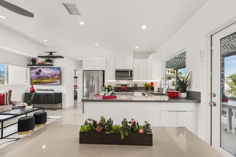 Open kitchen & living space w/ sleek finishes, large TV & room to gather