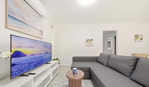 Bright lounge area with a comfy sofa bed and TV