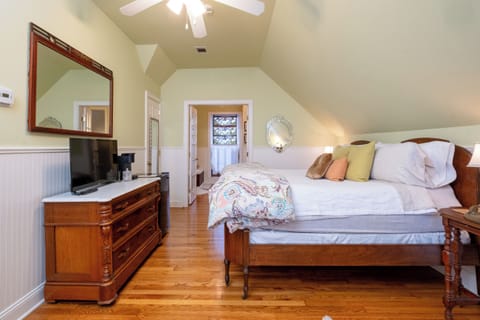 Alternate bedroom view highlighting antique furnishings, dresser, and sitting space.