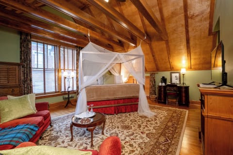 Wide view of the suite showcasing the vaulted ceiling, seating area, and refined, lodge-inspired character.