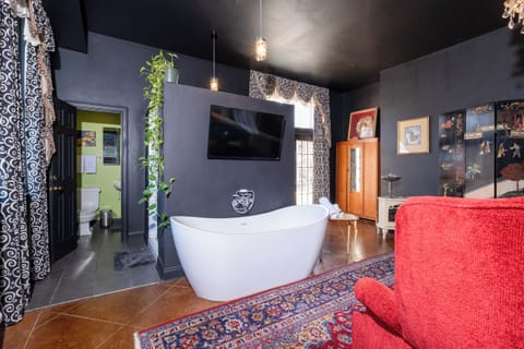 Open-concept layout highlighting the soaking tub, wall-mounted TV, and distinctive design details.