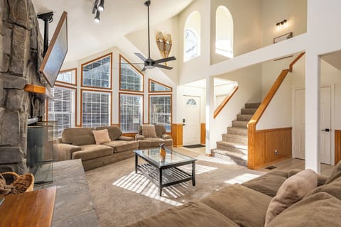Unwind in your spacious living room with soaring ceilings, cozy fireplace, and floor-to-ceiling windows that flood the space with natural light.