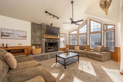 Spacious living room featuring comfy couches, stone fireplace, and sunny and bright..