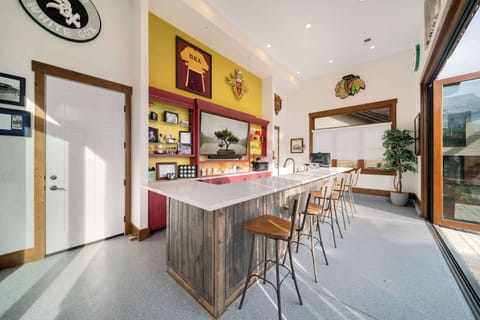 A full sized indoor/outdoor bar with bar seating, 85" smart TV, and glass doors that slide open to the lakefront breeze. The experience of entertainment in this space is 2nd to none.