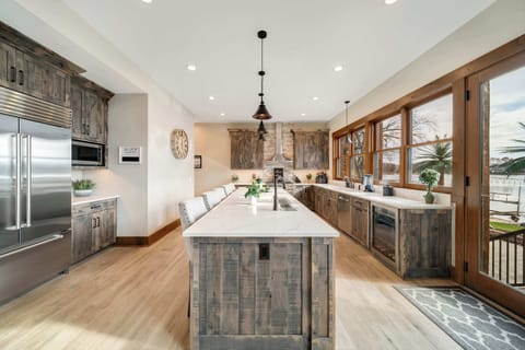 Our fully stocked gourmet kitchen is a showpiece, featuring designer cabinetry & a 12-foot quartz island with 6 barstools that face the lake.