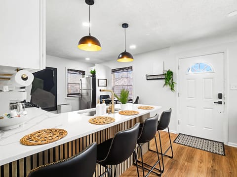 Spacious dining area w/ long table, pendant lights & open flow