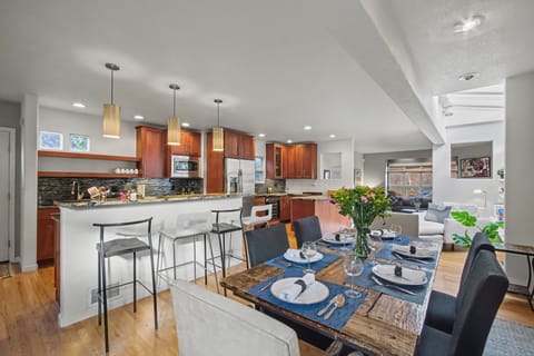 Dining area and fully stocked kitchen with wide array of pots, pans, utensils.