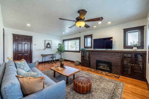 Bright and cozy living room with fireplace, hardwood floors, and smart TV, ideal for relaxing anytime.