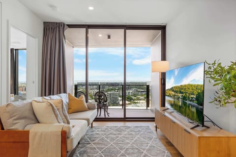 Light-filled living area opening out to the balcony with elevated river and city views.
