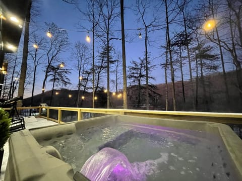 Private hot tub under the stairs | mountain view, cozy deck lighting, and perfect for peaceful & romantic evenings. 
