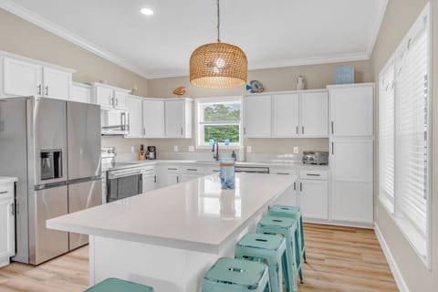 Modern cabinetry, stone countertops, and island seating inside a premier Florida Keys canal-front rental.