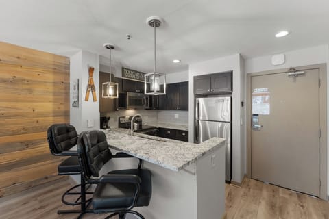 Full kitchen with stainless steel appliances and breakfast bar.