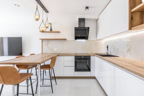 Modern elegant kitchen with wooden elements, warm tones, and clean design.
