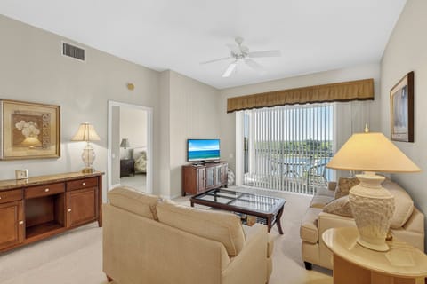 Relax in the living room with a comfortable sofa and loveseat, glass coffee table, and ceiling fan.