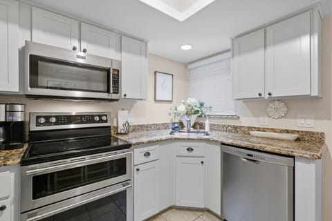 Enjoy cooking in this stylish beach stay kitchen with stainless steel appliances, granite countertops, and bright cabinetry. This well-equipped vacation rental makes it easy to prepare meals after a relaxing day by the beach.