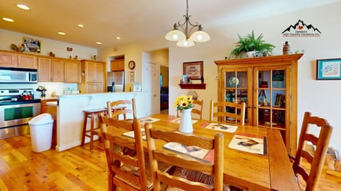 Gather around your warm wooden dining table while sunflowers brighten your fully-equipped kitchen, complete with modern appliances and cozy cabin charm.