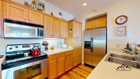 Your fully equipped kitchen features stainless steel appliances and warm wood cabinets, perfect for preparing memorable meals during your stay.
