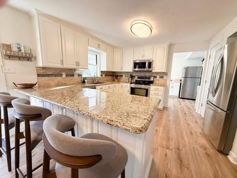 Cook, gather, and entertain in this bright, fully equipped kitchen with granite countertops and modern appliances.