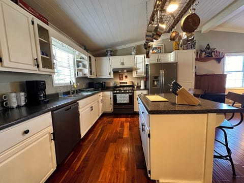 Fully stocked kitchen with coffee maker, gas range stove, microwave, full fridge