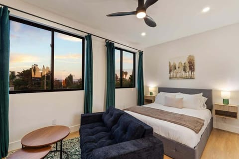 Spacious bedroom with large windows and sunset views