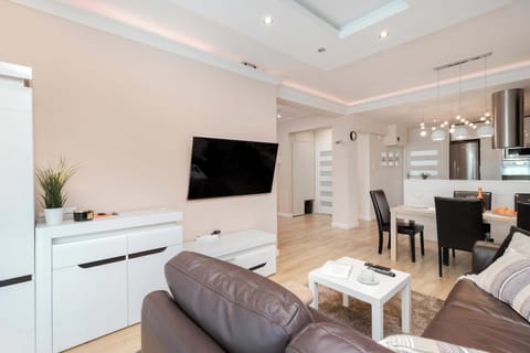 Another view of the open-plan living space with a dining table and sofa. The design balances comfort and style.