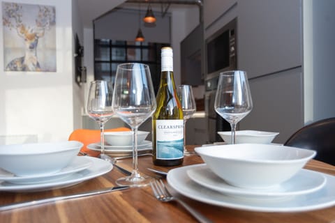 One of two dining tables seating four, fully set with plates, cutlery and glassware for the ultimate home-from-home experience — ask affluxi about our private dining experiences with our private chef.