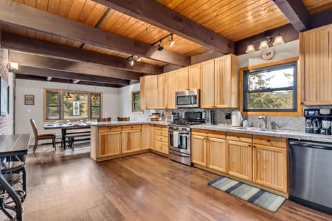 Cook, dine, and unwind in this inviting, light‑filled kitchen overlooking the trees.