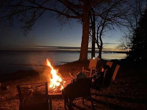 Unwind by the fire under a starlit sky! Enjoy peaceful lakefront nights with cozy seating and stunning sunset views