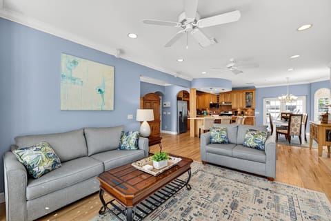 Elegant Captiva retreat featuring a spacious, light-filled living room with a fireplace, plantation shutters, and upscale coastal design.